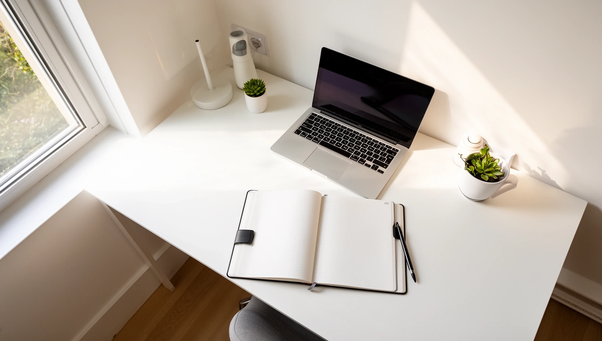 Schreibtisch mit Laptop und Notizbuch